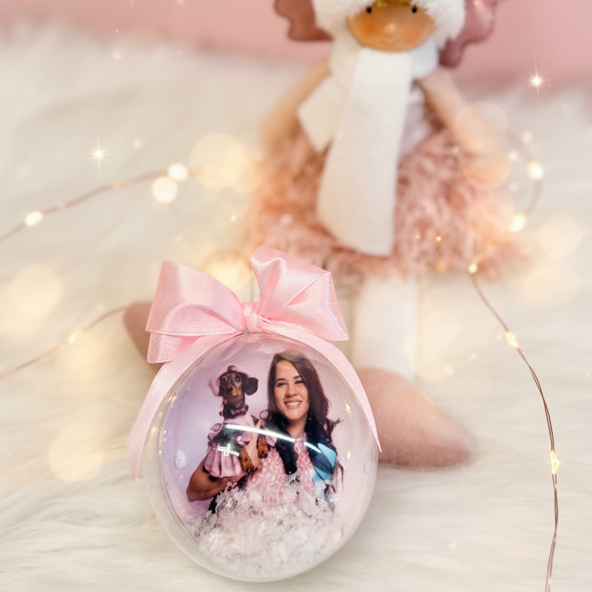 Adorno navideño personalizado con foto de persona y su mascota, bola transparente con lazo rosa y nieve decorativa de Sweet Gift.